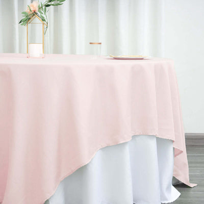 Pink tablecloth draping over a white table in a softly lit setting.