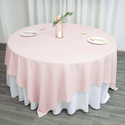 Round pink tablecloth draped elegantly over a white table.