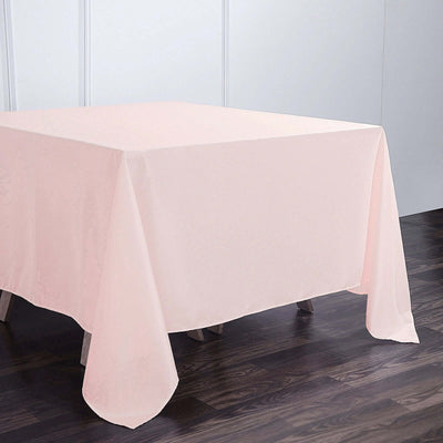 Pink tablecloth draped over a wooden table in a simple setting.