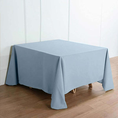 Blue tablecloth draped over a table on a wooden floor.