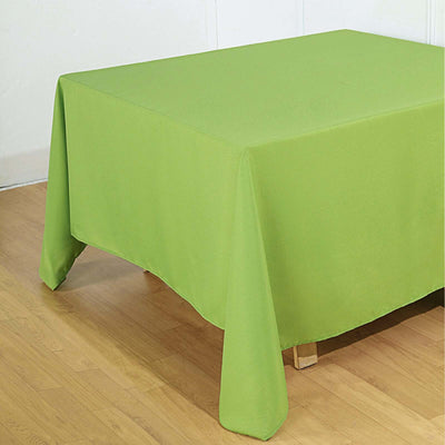 Green tablecloth draped over a wooden table