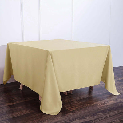 Yellow tablecloth draped over a table on a wooden floor.