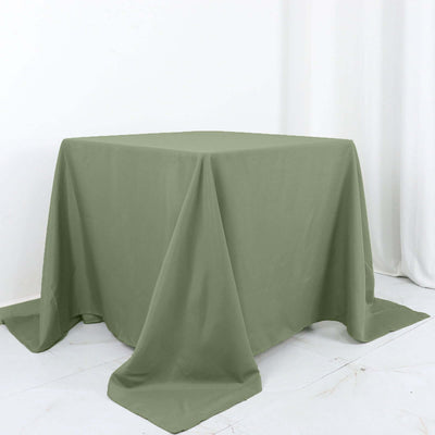 Green tablecloth draped over a square table on a white background.