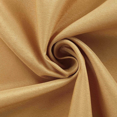 Golden fabric swirl texture close-up showing smooth, luxurious material.