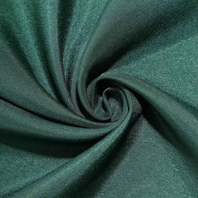 Textured dark green fabric in a spiral pattern.