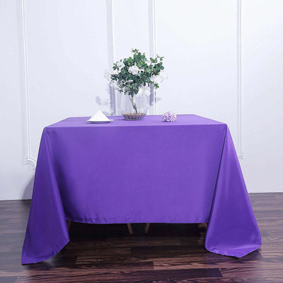 Purple tablecloth draped over a table with vase and decor