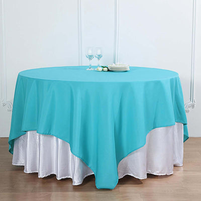 Turquoise round tablecloth draped over a white table