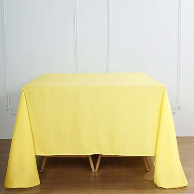 Yellow tablecloth draped over a wooden table in a bright setting.