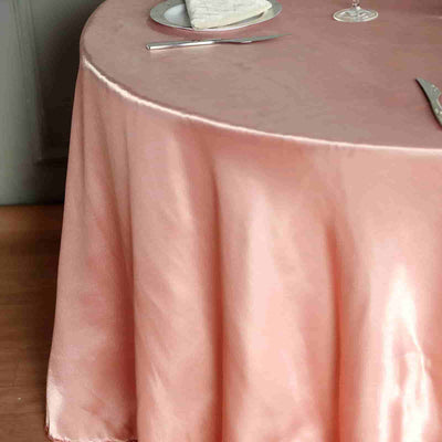 Elegant pink tablecloth draping over a table set for dining.
