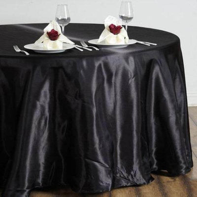 Black satin tablecloth elegantly draped on a round table set for dining.