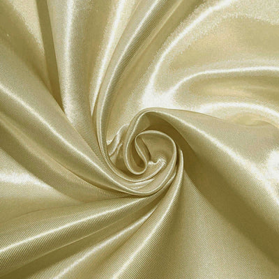 Gold satin fabric swirl texture close-up.