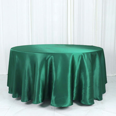 Green satin tablecloth draped over a round table.