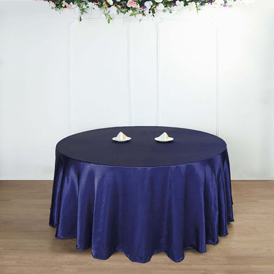 Round navy tablecloth elegantly draped on a table with decorative plates.