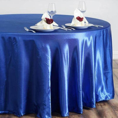 Blue satin tablecloth draped over a round table set for dining.