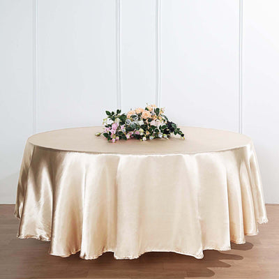 Round satin tablecloth in champagne color with floral centerpiece