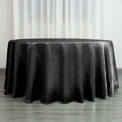 Black round tablecloth with a smooth finish on a wooden surface.