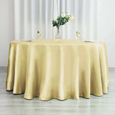 Elegant gold tablecloth draping a round table with floral centerpiece.