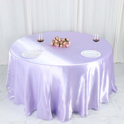 Elegant purple satin tablecloth with floral centerpiece and wine glasses.