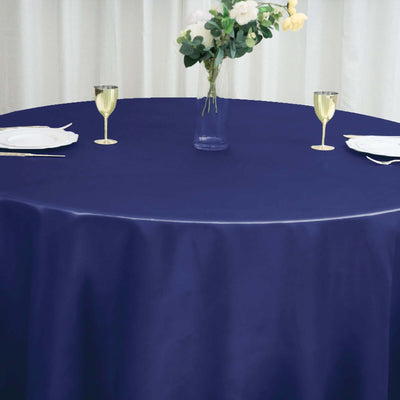 Navy blue tablecloth draping over a round table set for dining.