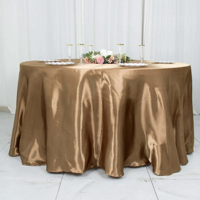 Brown satin tablecloth draped elegantly on a round table with floral decor.