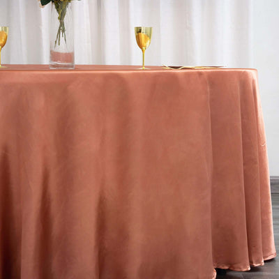Rose tablecloth draped elegantly over a table with decorative glassware.