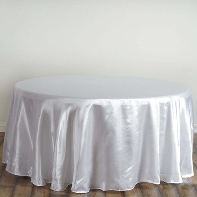 Round silver tablecloth on a wooden floor.