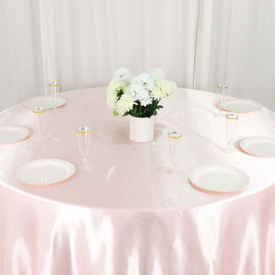 Elegant pink table setting with white floral centerpiece and glassware.