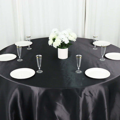 Elegant table setting with white plates and glasses, featuring a floral centerpiece.
