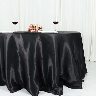Elegant black tablecloth with wine glasses and a floral centerpiece.
