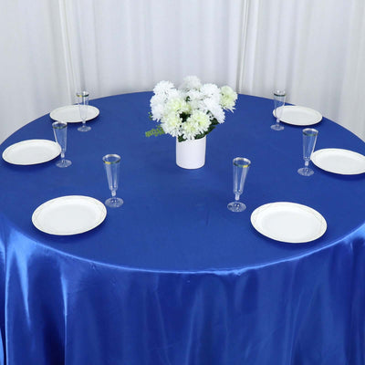 Blue table setting with white plates and a floral centerpiece.