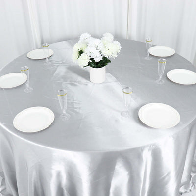 Elegant round table set with white plates and floral centerpiece.