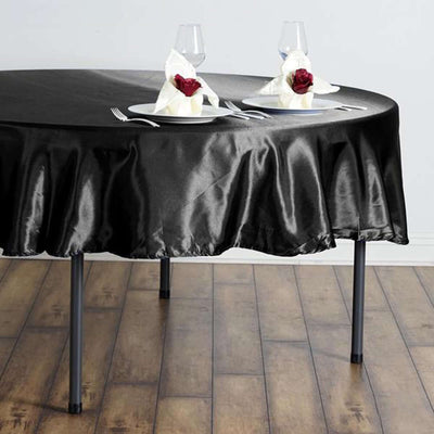 Black tablecloth draped elegantly over a round table with romantic decor.