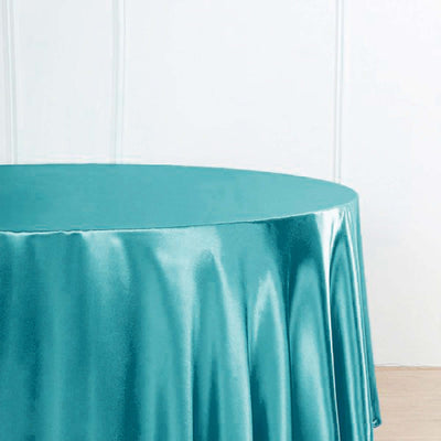 Teal satin tablecloth draped over a round table