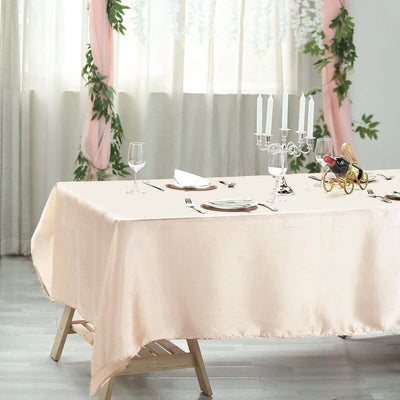 Elegant blush tablecloth set on a beautifully arranged dining table.