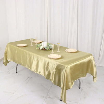Elegant gold satin tablecloth draped over a table set for a special occasion.