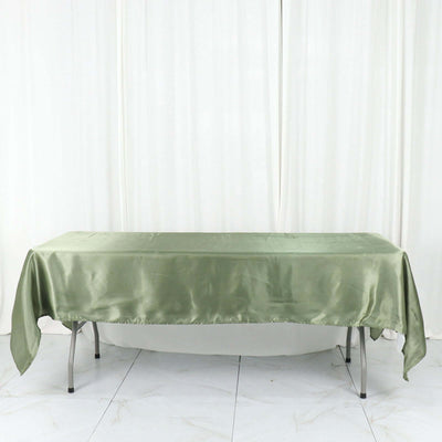 Satin green tablecloth on a table with a plain backdrop