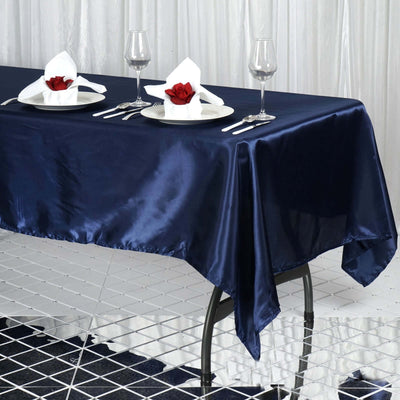 Navy satin tablecloth with elegant table setting and rose accents.