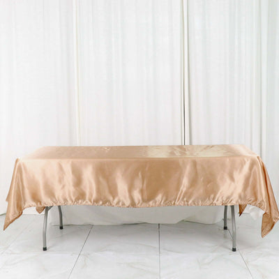 Gold satin tablecloth on a rectangular table in a studio setting
