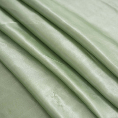 Smooth light green satin fabric draped elegantly.
