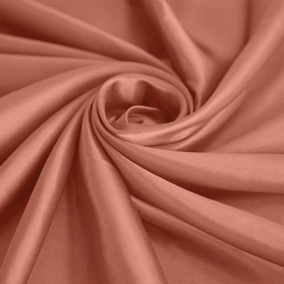 Soft coral fabric in a swirling pattern showcasing its smooth texture.