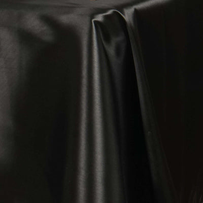 Glossy black tablecloth on a smooth surface.