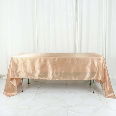 Peach satin tablecloth draped over a table in a studio setting.
