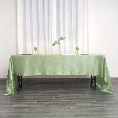 Elegant green tablecloth draped over a table with decor and glasses.