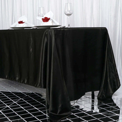 Elegant black tablecloth draping over a table set for dining.