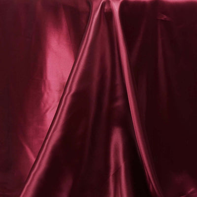 Burgundy satin fabric draped elegantly on a surface.
