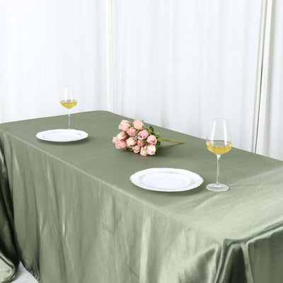 Elegant table setting with flowers and wine glasses on a green tablecloth.