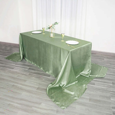 Green satin tablecloth draped elegantly over a dining table.