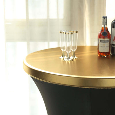 Elegant round bar table with gold top and glassware, perfect for entertaining.
