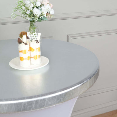 Dessert cups on a silver table with flowers in a vase.