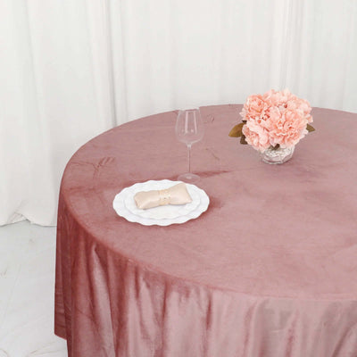 Elegant pink table setting with flowers and glassware.